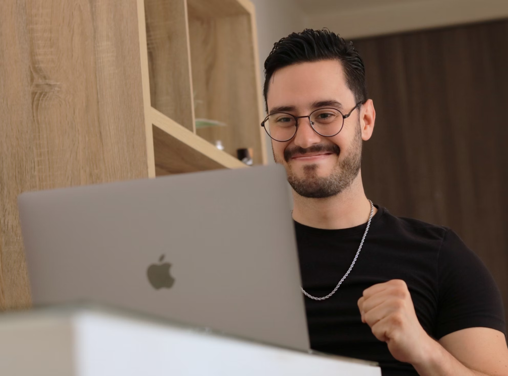 a man wearing glasses is looking at a laptop JpYWVC dnLw